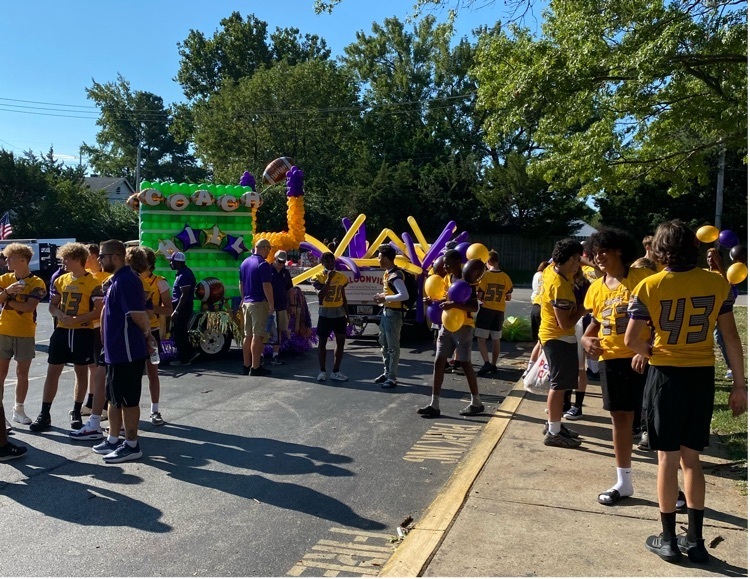 AHS football team stands next to the Art Hill memorial float prior to the Affton Days parade